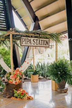 there is a sign that says pippa station with flowers on the ground in front of it