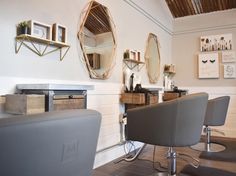 a hair salon with chairs and mirrors on the wall next to it's counter