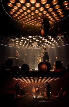 a group of people that are standing in front of a stage with lights on it