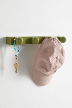 a hat and necklace hanging on a coat rack