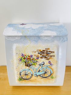 a decorative box with a painting of a bicycle and flowers in the basket on it