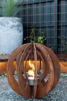 an outdoor fire pit in the shape of a sphere with flames coming out of it