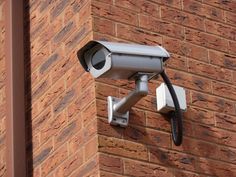 a security camera attached to the side of a brick building