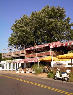 a scooter parked in front of a restaurant on the side of the road