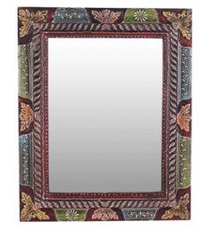 a decorative mirror with an ornate design on the front and sides, hanging from a wall