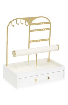 a white and gold desk organizer with two drawers on each side, one drawer open to reveal a roll of paper