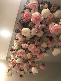 pink and white flowers hanging from the ceiling