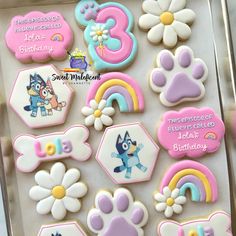 decorated cookies in the shape of paw patrol and rainbows, flowers, and numbers