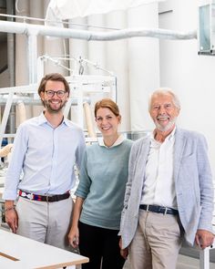 two men and a woman standing next to each other