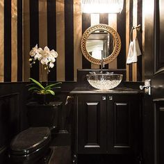 a bathroom with black and gold striped walls