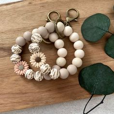 a wooden cutting board topped with bracelets and flowers