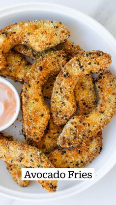 some fried food on a white plate with dipping sauce