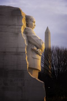 the washington d c monument is lit up with yellow light as it stands in front of an obelisk