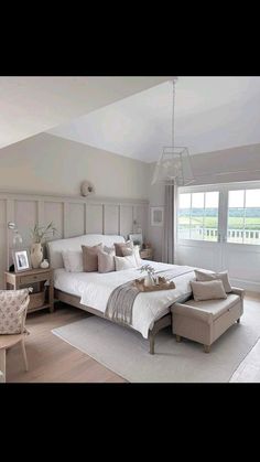 a large bed sitting in the middle of a bedroom next to a chair and table