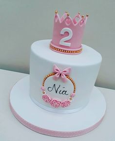 a two tiered cake with a pink crown on top and the number 2 on it