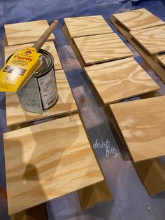 a can of paint sitting on top of plywood planks next to some wood boards