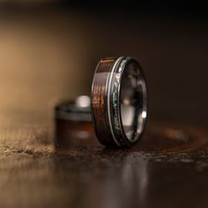 two wedding rings with wood inlays on a table