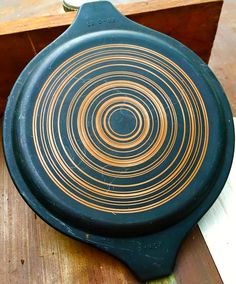 an old frying pan sitting on top of a wooden table