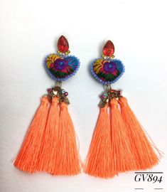 two pairs of earrings with tassels on top of each other in orange and blue