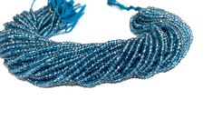 a blue bracelet with beads and tassels on white background, close - up