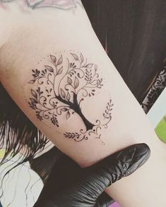 a woman's arm with a tree tattoo on the left side of her body