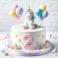 a birthday cake decorated with balloons and a unicorn on the top is for two year old