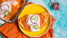 two plates filled with food sitting on top of a blue and orange table cloth next to each other