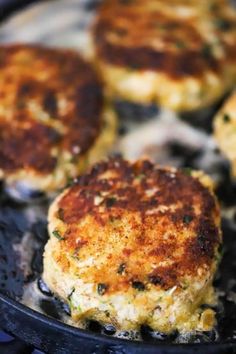 some crab cakes are cooking in a skillet