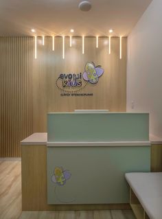 the front desk of an empty children's playroom with wooden walls and ceiling lights