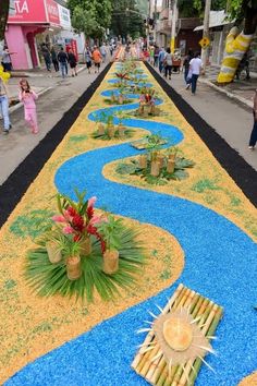 a long row of fake river made out of grass and bamboo sticks with flowers on each side