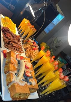 a table topped with lots of different types of sandwiches and fruit on top of plates