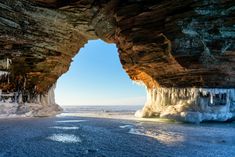 an ice cave with icicles hanging from it's sides and water running down the side