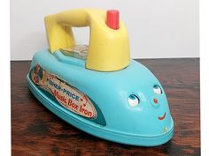 a blue toy boat sitting on top of a wooden table