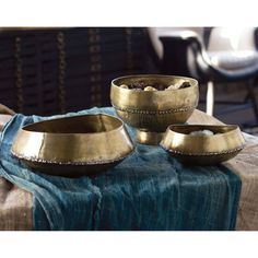 three brass bowls sitting on top of a table