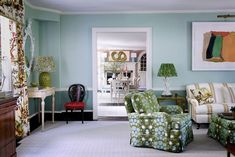 a living room filled with lots of furniture next to a painting hanging on the wall