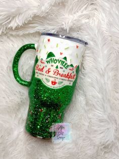 a green glittered coffee mug with the words whoville bed and breakfast on it