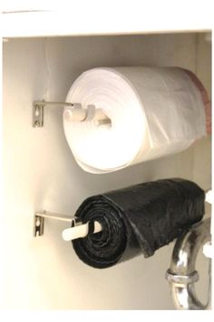 two rolls of toilet paper are hanging on the wall next to a sink faucet