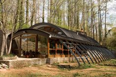 an unusual house in the woods is made from metal pipes and steel tubes, which are attached