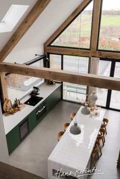 an aerial view of a kitchen and dining room area in a loft style home with large windows