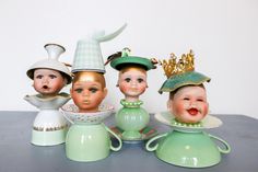 five porcelain figurines with hats on top of each one, sitting on a table