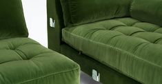 two green velvet couches sitting next to each other