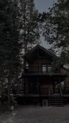 a large wooden house surrounded by trees at night