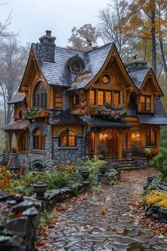 a house in the woods with lots of windows and plants on it's roof