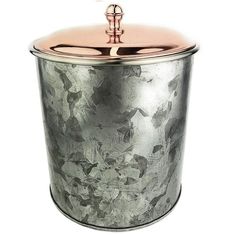 a large metal container with a rose pattern on the lid and handle is shown in front of a white background