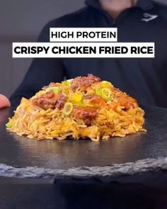 a man holding a plate with food on it and the caption reads, high protein crispy chicken fried rice