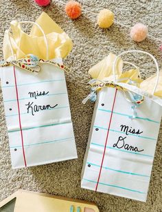 two paper bags with writing on them sitting on the floor