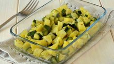 a glass casserole dish filled with zucchini and squash