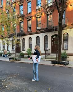 a woman standing in the middle of an empty street with her hand on her hip