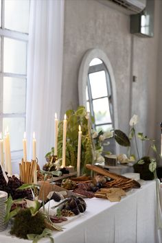 Grazing table with cheese, bread, figs, and meats. Tapered candles and green florals with bows decorate the table. Minimalist Grazing Table, Aesthetic Grazing Table, Grazing Table Wedding Cocktail Hour, Italian Grazing Table, Diy Grazing Table, Cheese Table Wedding, Christmas Grazing Table, Charcuterie Table