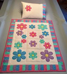 a quilted bed with colorful flowers on it